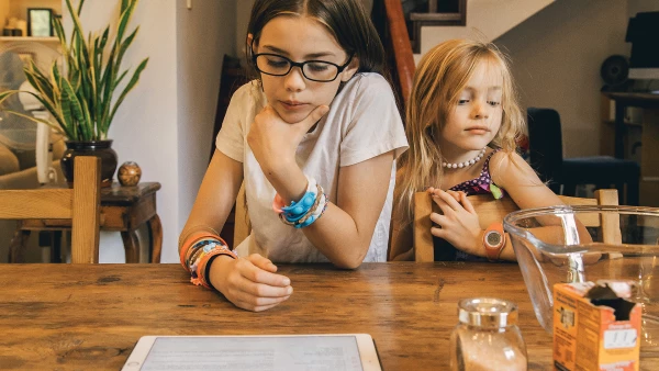 online AP classes offered by lifeplus online academy for advanced learners like these girls at the kitchen table