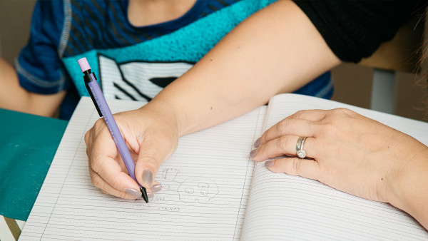 Close up shot of mother and son writing in journal