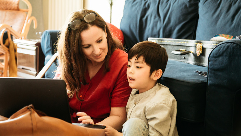 Mother works with son on computer